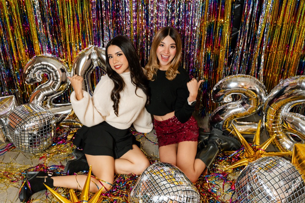 Dos amigas sentadas en el set de Año Nuevo, con estrellas doradas
